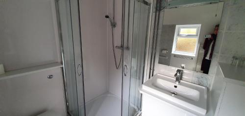 a white bathroom with a sink and a shower at Edward Hotel in Gloucester