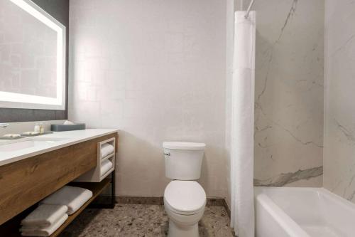 a bathroom with a toilet and a sink and a tub at La Quinta Inn & Suites by Wyndham Santa Rosa Sonoma in Santa Rosa