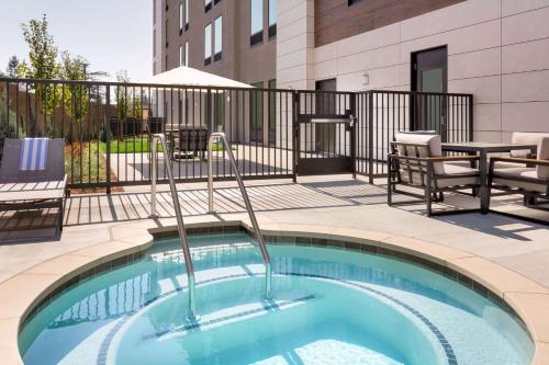 a swimming pool with chairs and a table on a balcony at La Quinta Inn & Suites by Wyndham Santa Rosa Sonoma in Santa Rosa