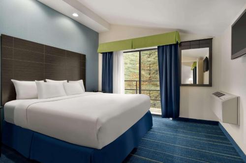 a large bed in a room with a large window at Days Inn by Wyndham Tamworth in Tamworth