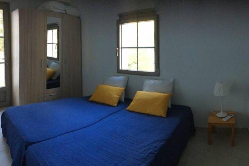 - une chambre avec un lit bleu et 2 oreillers jaunes dans l'établissement Appartement à cavalaire dans un domaine privé au rez-de-jardin, à Cavalaire-sur-Mer