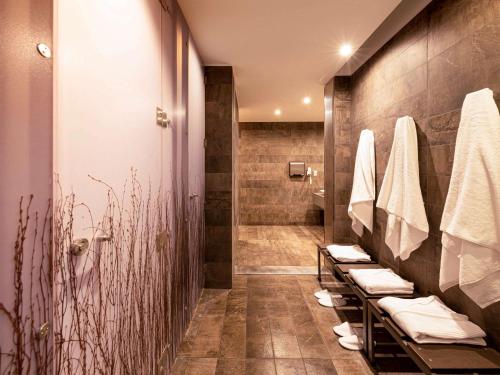 a bathroom with a shower with towels and sinks at Novotel Vina del Mar in Viña del Mar