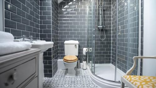 uma casa de banho com um WC, um chuveiro e um lavatório. em Lovely Coach House with Free Parking em Cardiff
