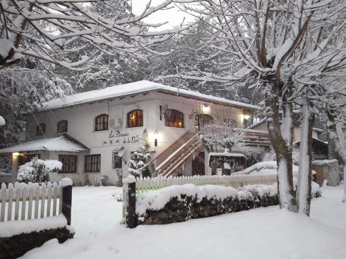 a snow covered house with a fence in front of it at Posada de la Flor in San Carlos de Bariloche