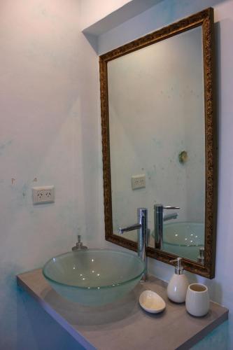 a bathroom with a glass sink and a large mirror at Allegra Dalila Casa Hotel-Arte in Tandil