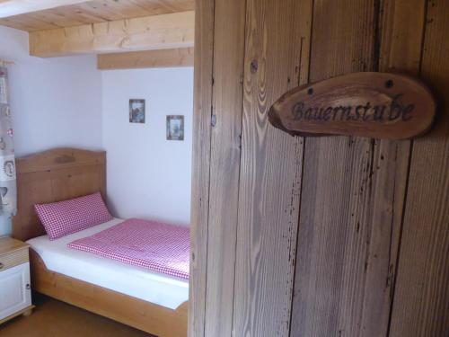 a small bedroom with a bunk bed with pink sheets at Holstein-Höfle, Rindalphorn in Argenbühl