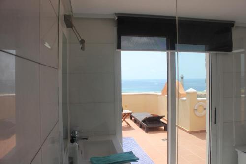 a bathroom with a shower with a view of the ocean at Villa coralin in Morro del Jable