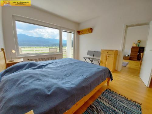 a bedroom with a bed and a large window at Apartment Toni by FiS - Fun in Styria in Bad Mitterndorf