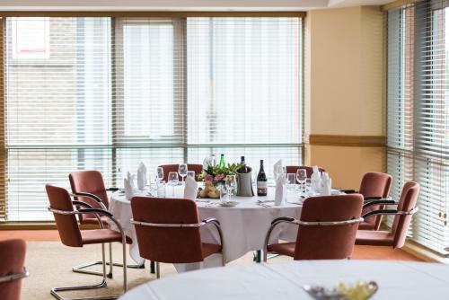 a conference room with a table and chairs and windows at Leonardo Hotel Sheffield in Sheffield