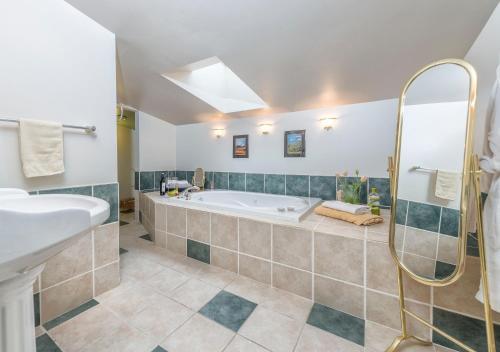 a bathroom with a tub and a sink at Tall Trees Bed & Breakfast in Prince Rupert