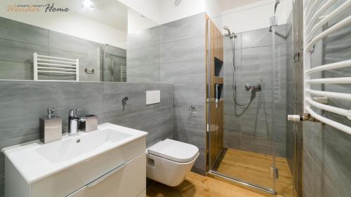 a bathroom with a toilet and a sink and a shower at Wonder Home - Apartamenty blisko parku wodnego, wyciągów narciarskich i Kościoła Wang in Karpacz