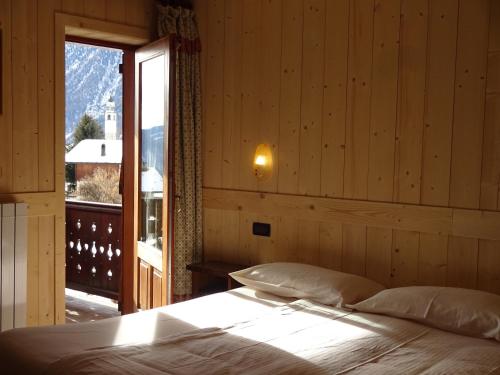 a bedroom with a bed and a large window at Santa San in Champoluc
