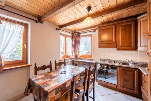 a kitchen with a table and some windows at Santa San in Champoluc