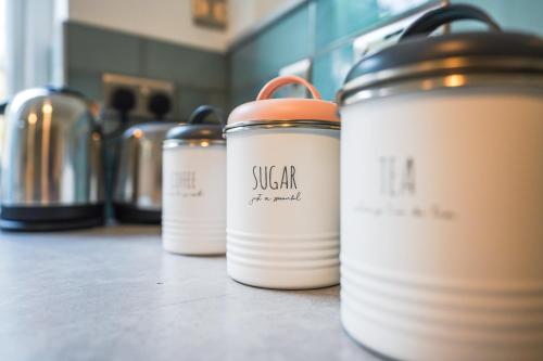 a row of coffee cans sitting on a counter at Private, Detached Annex with On-Street Parking in Cardiff