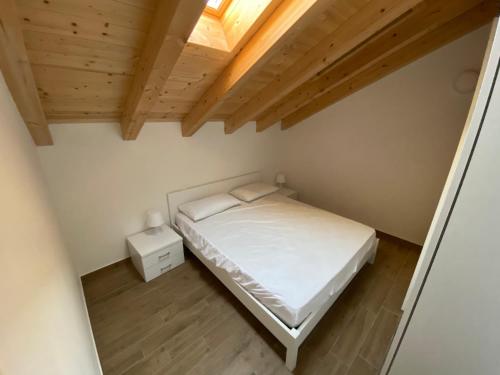 - une petite chambre avec un lit et un plafond en bois dans l'établissement Villa Canepa, à Diano Marina