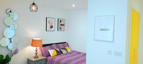 ein Schlafzimmer mit einem lila Bett und einer Lampe in der Unterkunft Great Studio Serviced Apartments - Netflix, Wifi, Digital TV in Sheffield