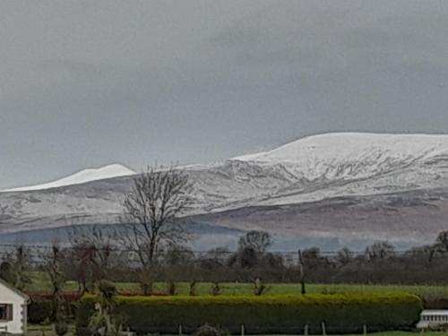 a snow covered mountain in the distance with a house at Annaswood B&B in Cahir