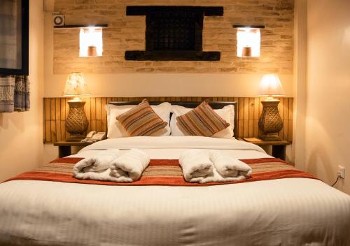 een slaapkamer met een groot bed en handdoeken bij Nepal Pavilion Inn in Kathmandu