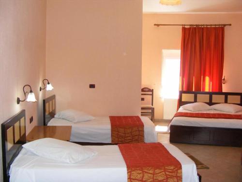 a hotel room with two beds and a window at Hotel George in Korçë