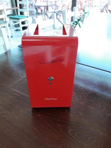 a red trash can sitting on a wooden floor at Dogana Vecchia - Hotel & Residence B&B Ristorante & Pizzeria in Trivignano Udinese