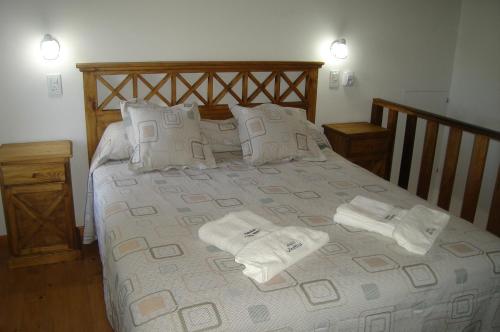 a bedroom with a bed with towels on it at Cabañas Aldea Serrana in Sierra de la Ventana