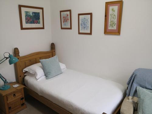 a bedroom with two beds and pictures on the wall at Sunset Guest House in Hunstanton