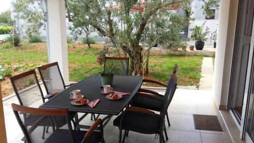 un tavolo nero e sedie su un portico di Family Holiday Home a Turanj (Torrette)