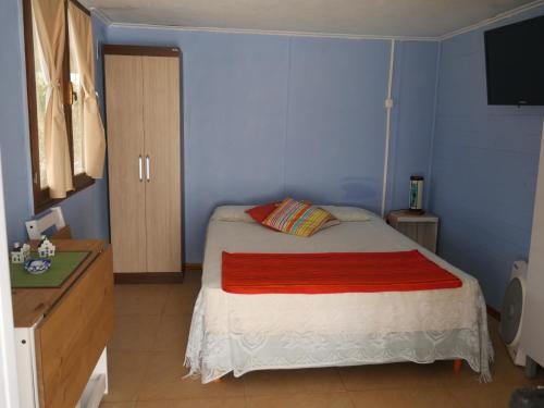 a bedroom with a bed and a dresser and a television at HansAna Blue in Barra de Valizas