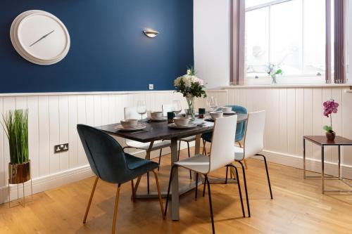 a dining room with a black table and chairs at Plymouth Central Duplex Apartment - Private Parking - Sleeps 6 - Habita Property in Plymouth