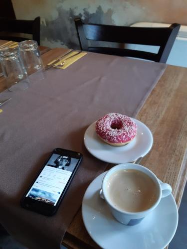 einen Tisch mit einem Handy, einem Donut und einer Tasse Kaffee in der Unterkunft Villa Di Poletta in Dobritsch