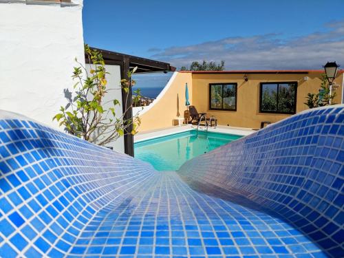 勞羅塔瓦的住宿－Casa Buena Vista，一座位于房子一侧的蓝色瓷砖游泳池