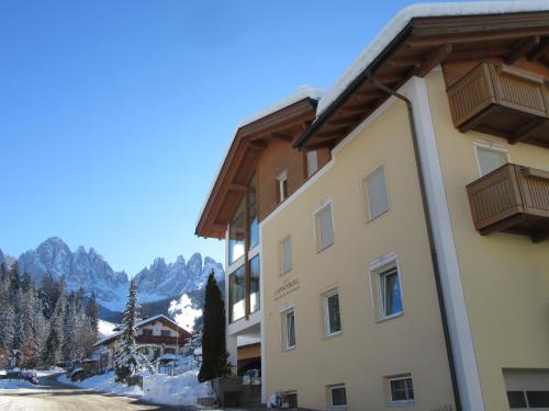 a view of a building with mountains in the background at Haus Tannenburg in Funes