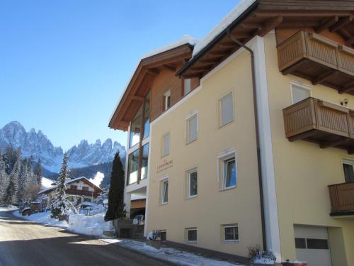 a building in the mountains with snow on the ground at Haus Tannenburg in Funes