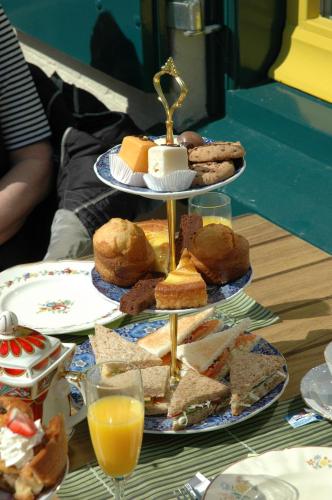 a table with three tiers of food and orange juice at Hotel Vierhouten in Vierhouten