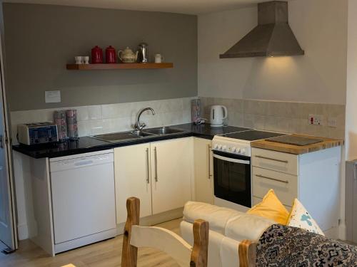 una cucina con lavello e fornello forno superiore di Hill House - Mews Town House, in a quiet private close, in the City Centre of Inverness. a Inverness