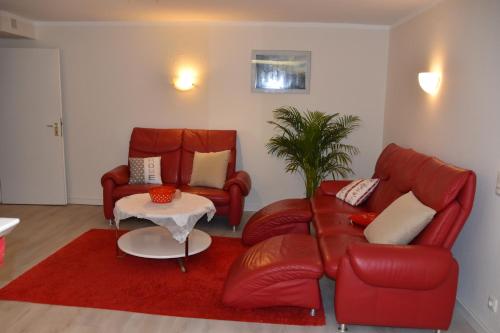 a living room with two red leather chairs and a table at Ferienwohnung Jannack für 5 Personen in Bad Münder in Bad Münder am Deister