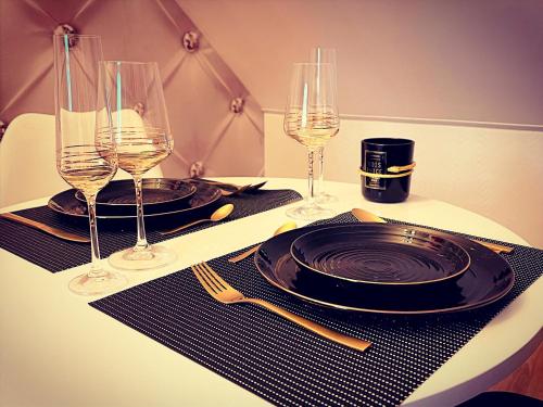 a table with two plates and glasses of wine at Redroom Loveroom Chambre Spa privative Insolite Thème 50 nuances de grey in Douchy-les-Mines