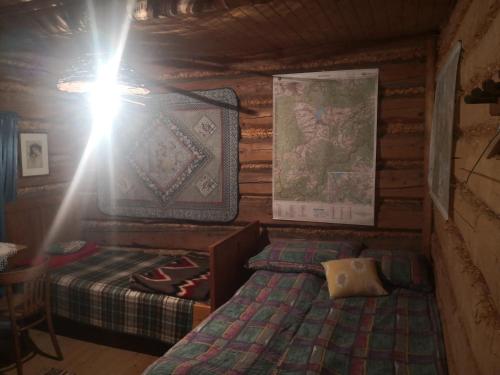 - une chambre avec un lit dans une cabane en rondins dans l'établissement Caputówka 100 letnia chata, à Rajcza