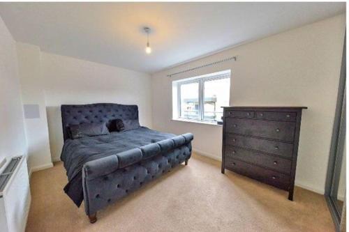 a bedroom with a blue bed and a dresser at Keys2door in London