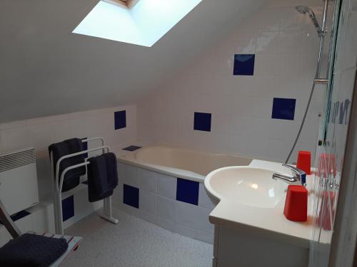 a bathroom with a tub and a sink and a shower at Ferme des capucines 