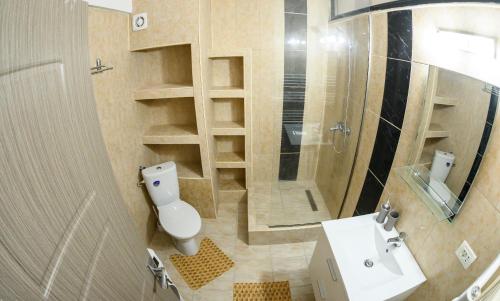 a bathroom with a toilet and a sink and a shower at Etiquette Studios Mamaia in Constanţa