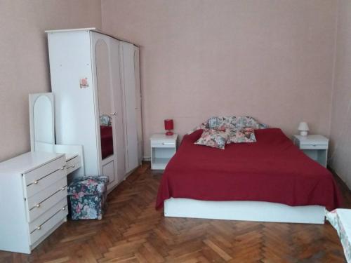リヴィウにあるKvartira na B Khmelnytskohoのベッドルーム1室(赤いベッド1台、ナイトスタンド2台付)