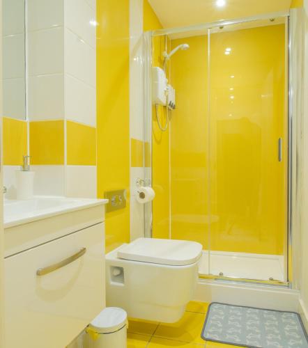 a bathroom with a toilet and a glass shower at Modern Studio Apartments Sheffield City Centre - Netflix, WiFi, Digital TV in Sheffield