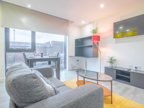 Modern Studio Serviced Apartments Sheffield City Centre - Netflix, WiFi, Digital TV في شيفيلد: غرفة معيشة مع أريكة وطاولة