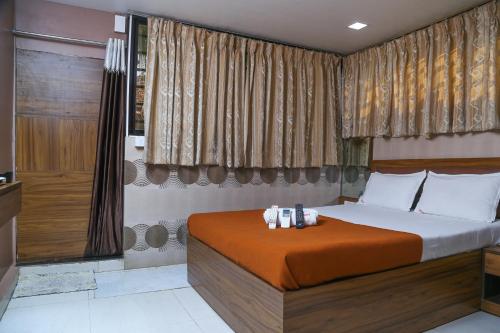 a bedroom with a large bed with brown curtains at Welcome Guest House in Mumbai