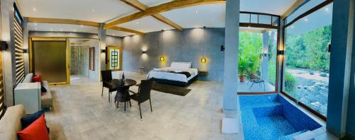1 dormitorio con 1 cama y 1 mesa en una habitación en Saguamby Mindo Lodge en Mindo