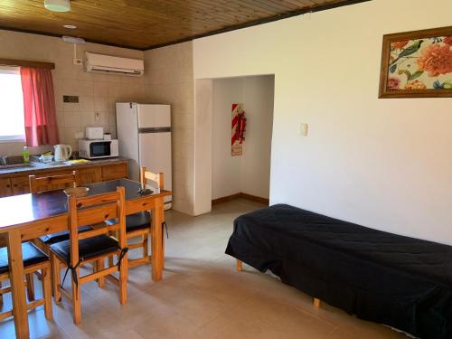 cocina y comedor con mesa y cama en Complejo Cabañas Cerro Redondo en Tandil
