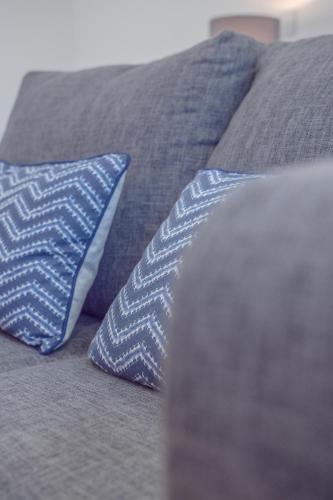 two blue and white pillows on a bed at Modern Studio Apartments Sheffield City Centre - Netflix, WiFi, Digital TV in Sheffield