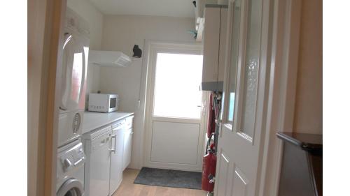 a kitchen with a white refrigerator and a window at Chalet Buutengeweun, met luxe JACUZZI en TONSAUNA in Sint Annaland