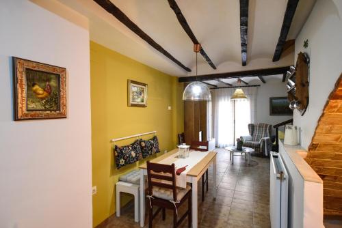 LA CASICA في سيجوربي: غرفة معيشة بجدران صفراء وطاولة وكراسي